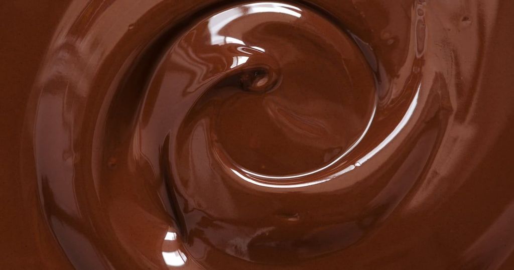 A close-up shows a swirling, glossy stream of melted chocolate.
